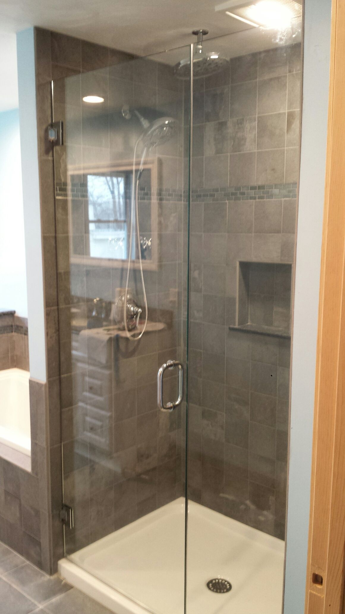 A bathroom with a walk in shower and a sink.