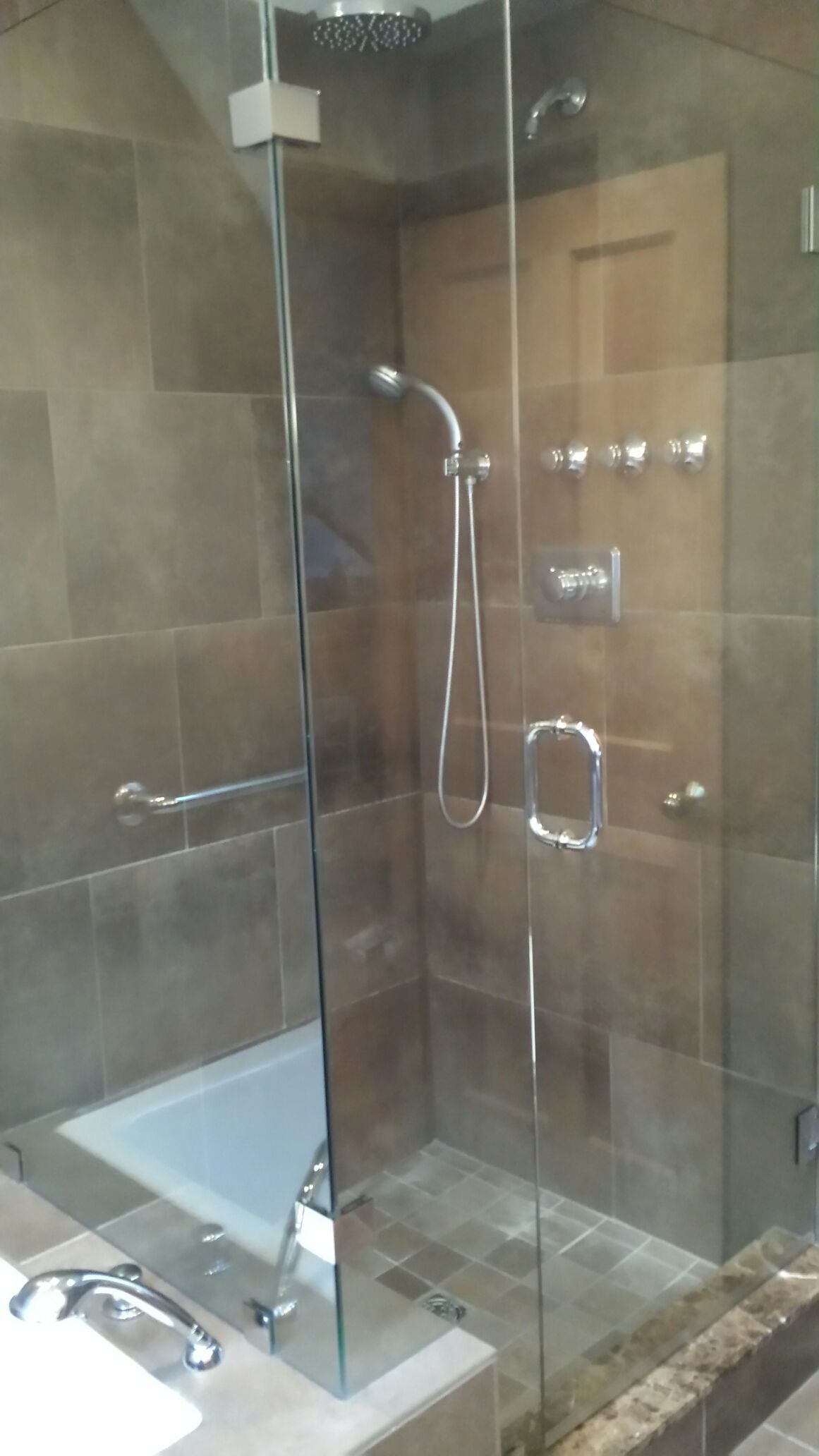 A bathroom with a bathtub and a shower with a glass door.