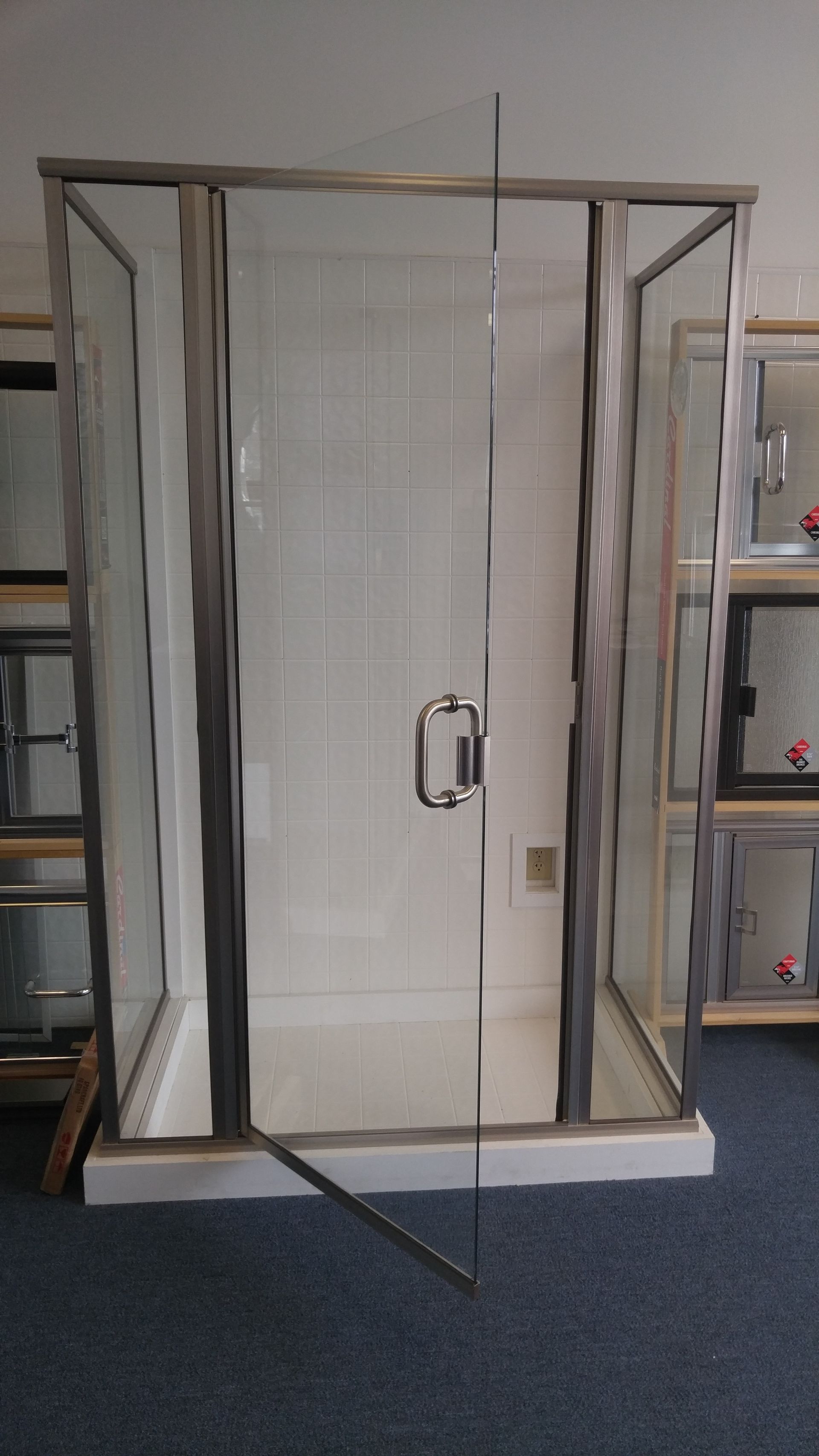 A shower stall with a glass door is sitting in a room.