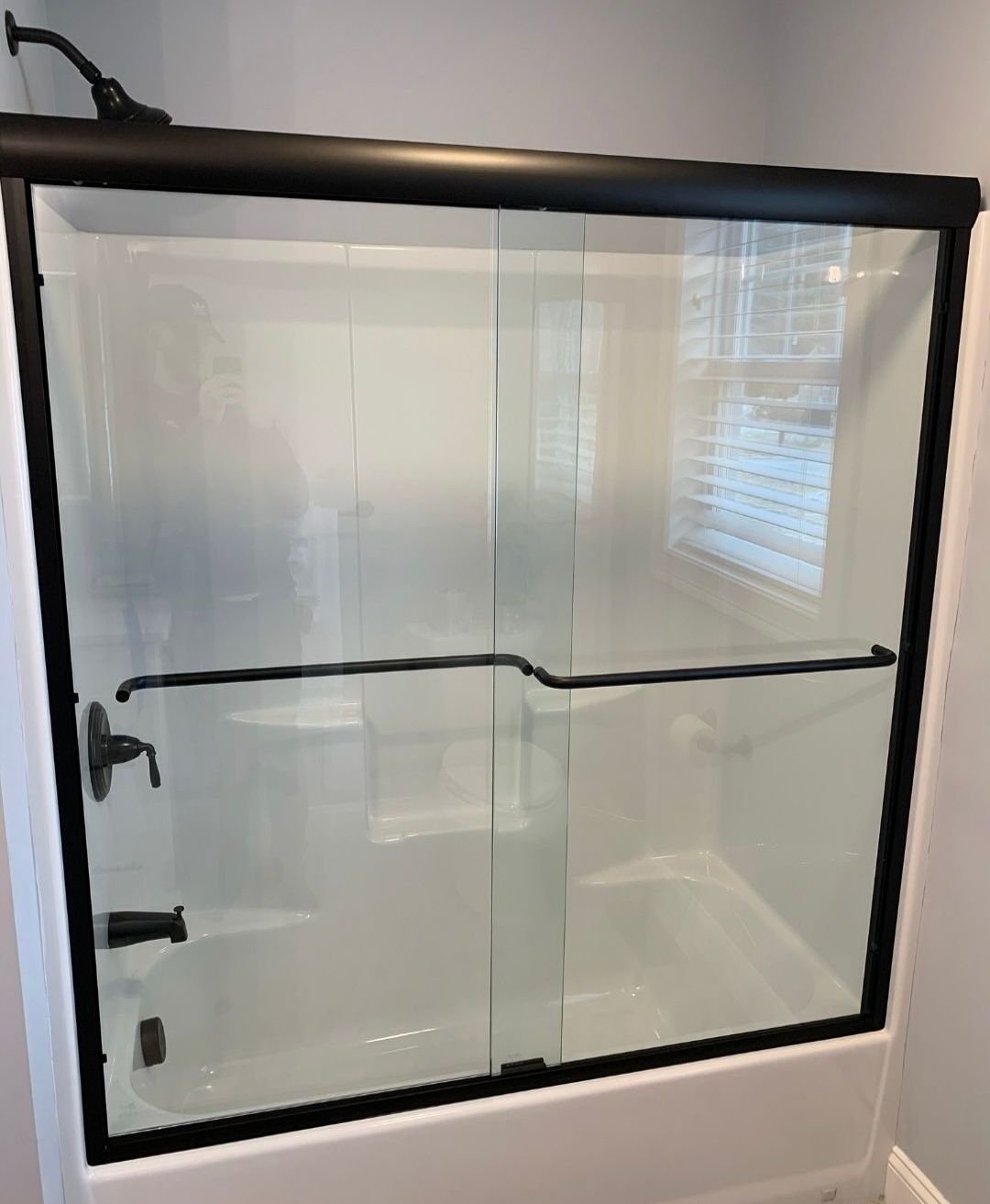 A bathroom with a sliding glass shower door and a bathtub.