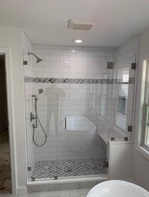 A bathroom with a walk in shower and a bathtub.