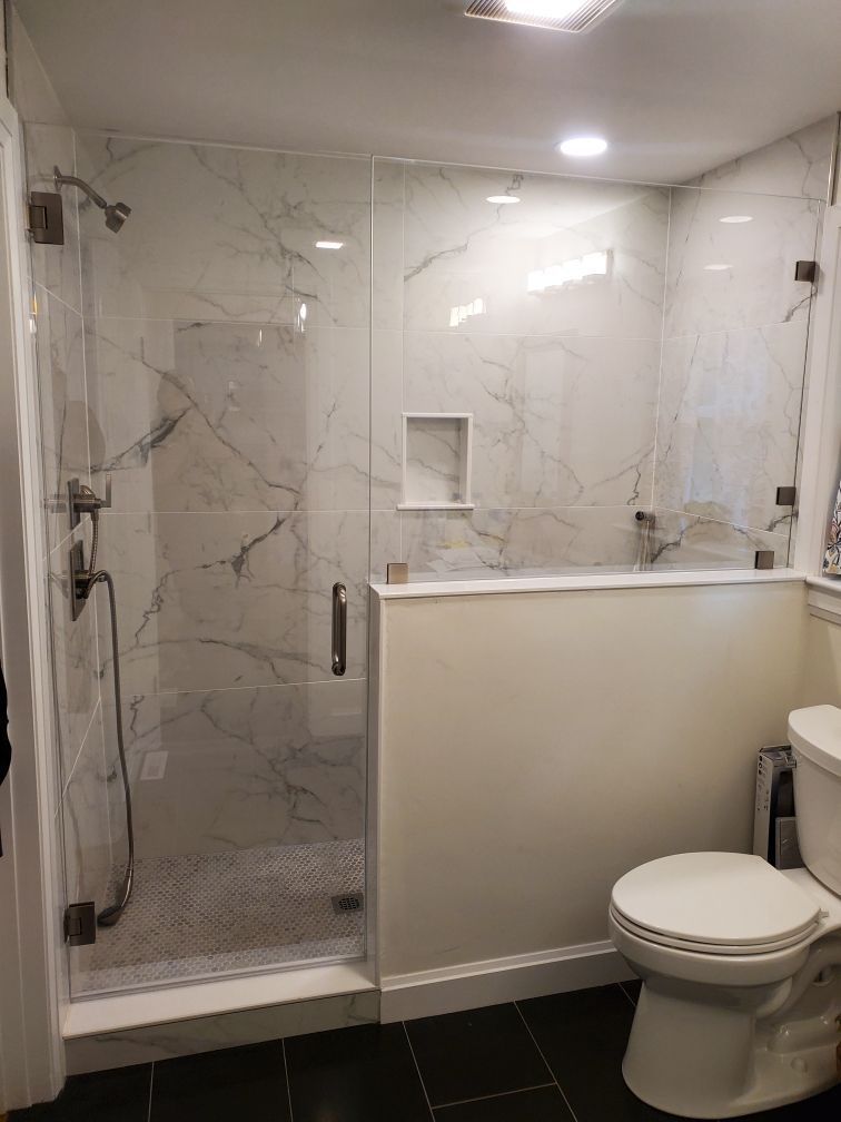 A bathroom with a toilet and a walk in shower.