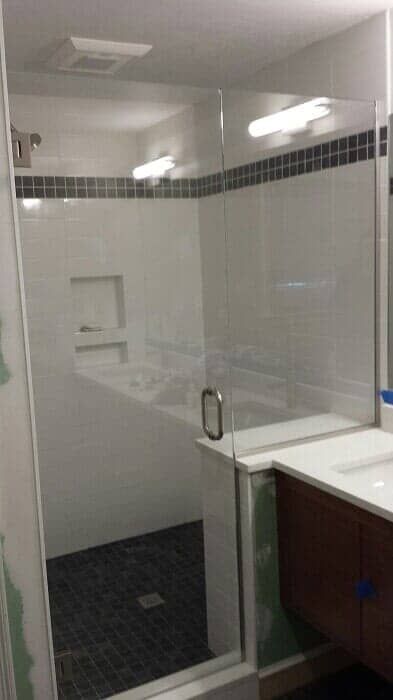 A bathroom with a walk in shower and a sink.