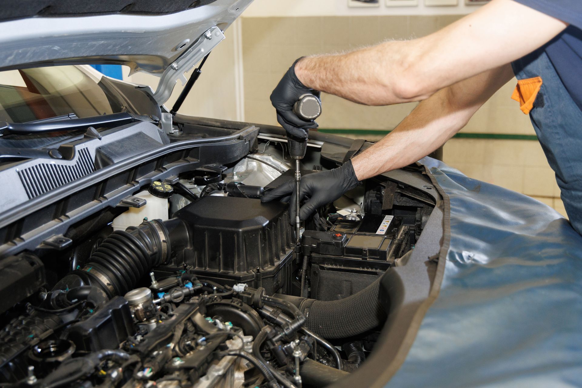 A man is working on the engine of a car.