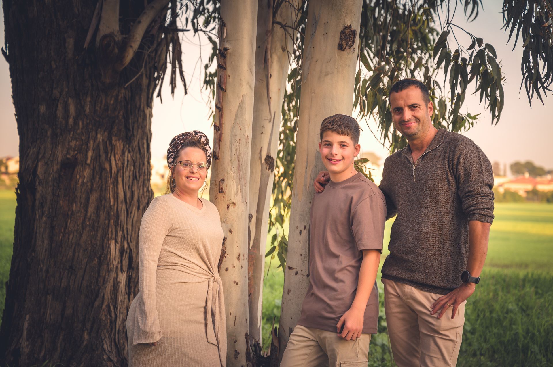 הורים וילד בר מצווה ליד עצים בחורשה