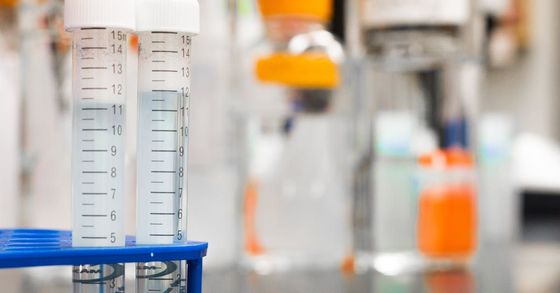 A close up of two test tubes in a blue holder in a laboratory.