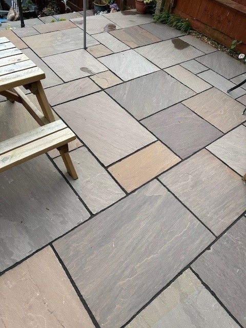 A patio with a picnic table and chairs on it