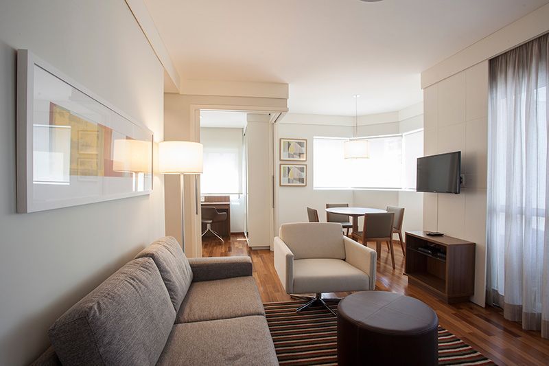 Sala de apartamento de alto padrão no eConfor Vila Olímpia, com décor moderno, sofá confortável, área de jantar iluminada e ambiente clean.