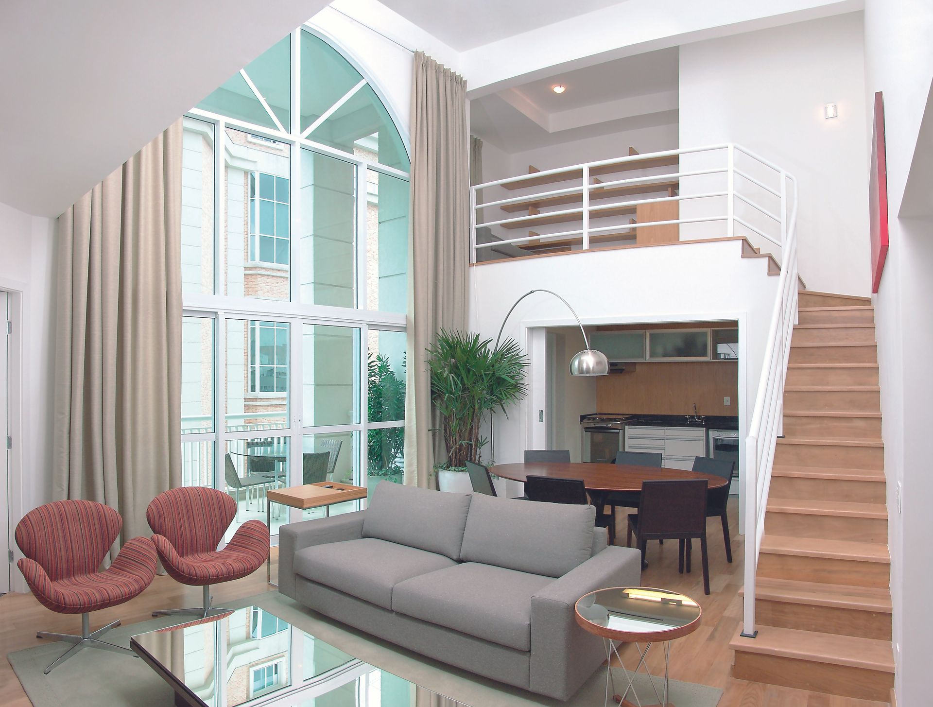 Duplex de alto padrão do eConfor Jardins, com pé-direito duplo, sala ampla iluminada, cozinha integrada e mezanino moderno.