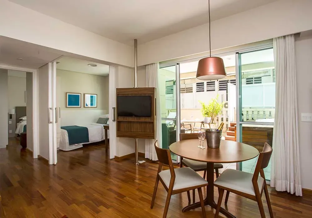 Há uma mesa e cadeiras no meio da sala.