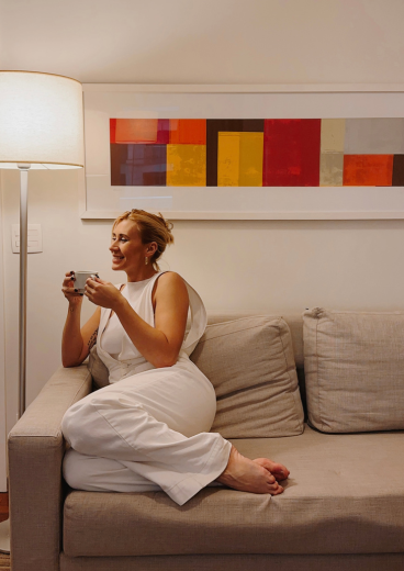 Uma mulher está sentada em um sofá segurando uma câmera