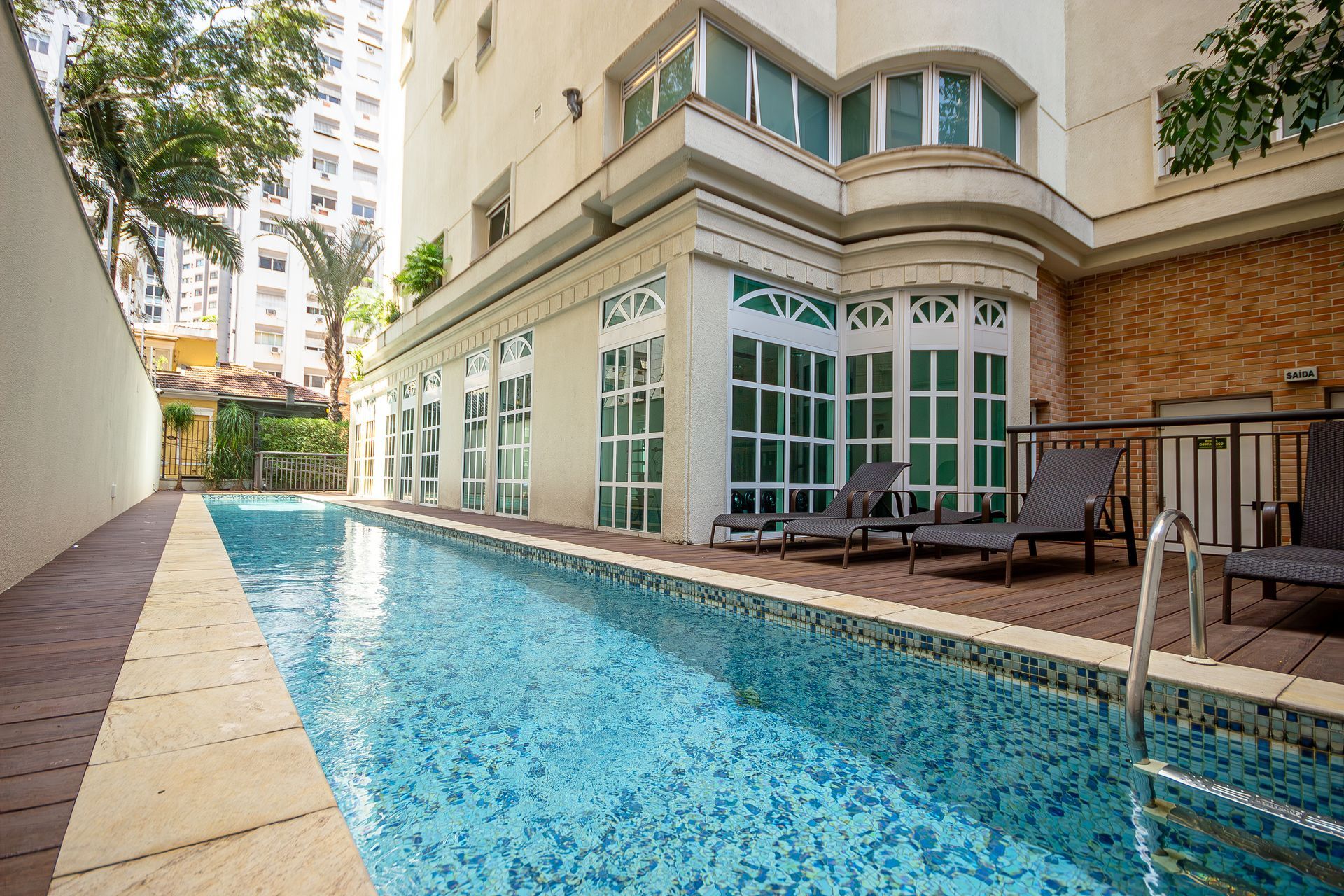 Há uma grande piscina em frente a um prédio.