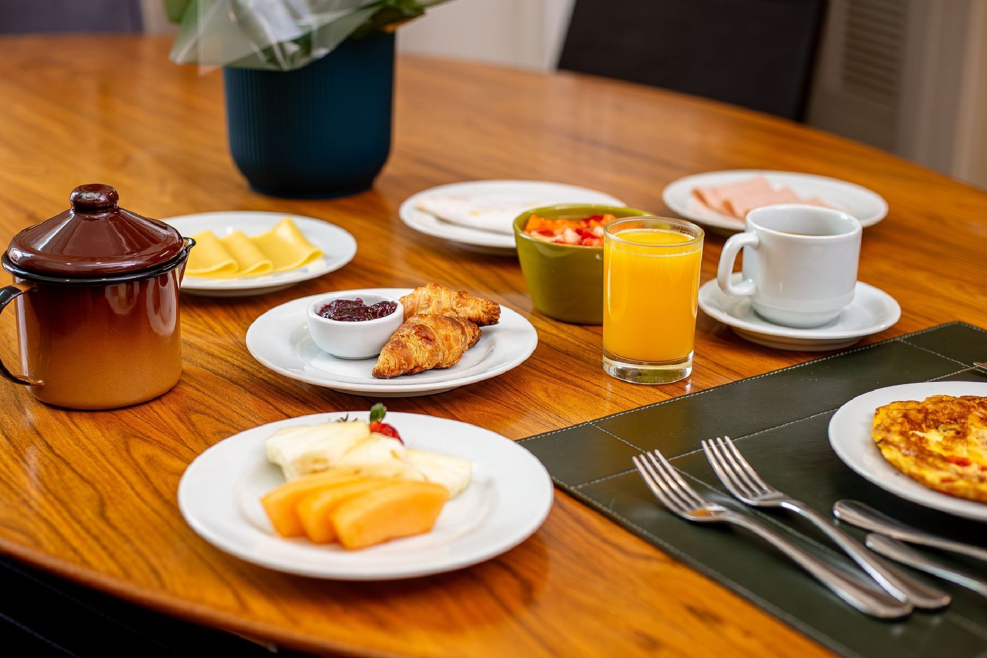 Uma mesa de madeira coberta com pratos de comida e bebidas.