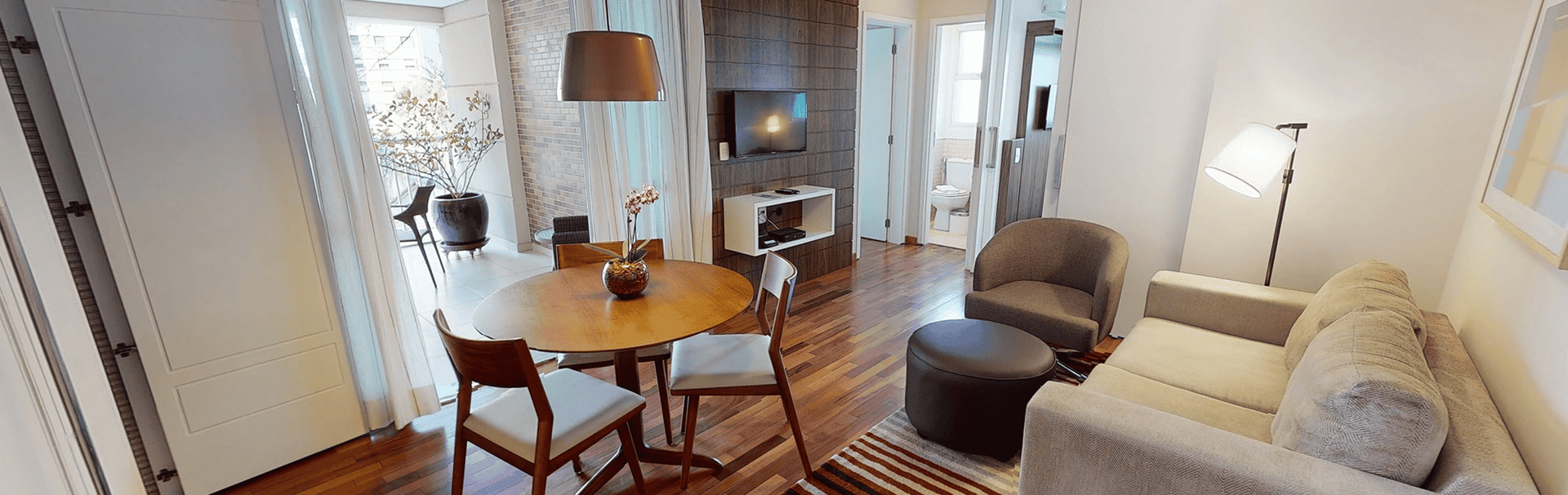 Ambiente elegante no eConfor Paulista, com sala integrada ao quarto, décor contemporâneo e atmosfera acolhedora ideal para viver e trabalhar com conforto superior.