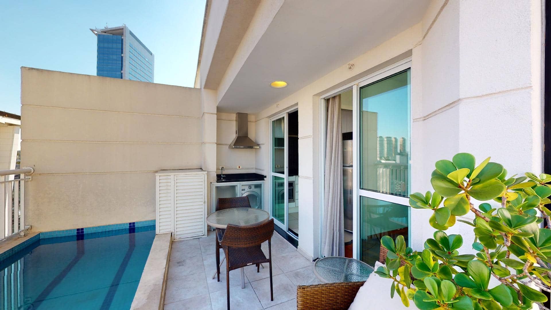 Varanda de alto padrão no eConfor Vila Olímpia, com piscina privativa, espaço gourmet e vista urbana privilegiada.