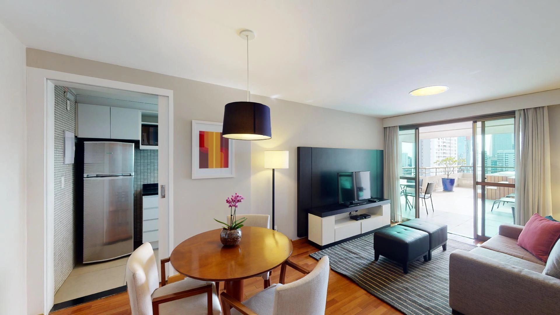 Cozinha integrada a sala e varanda com vista para São Paulo em apartamento de alto padrão da eConfor Berrini.