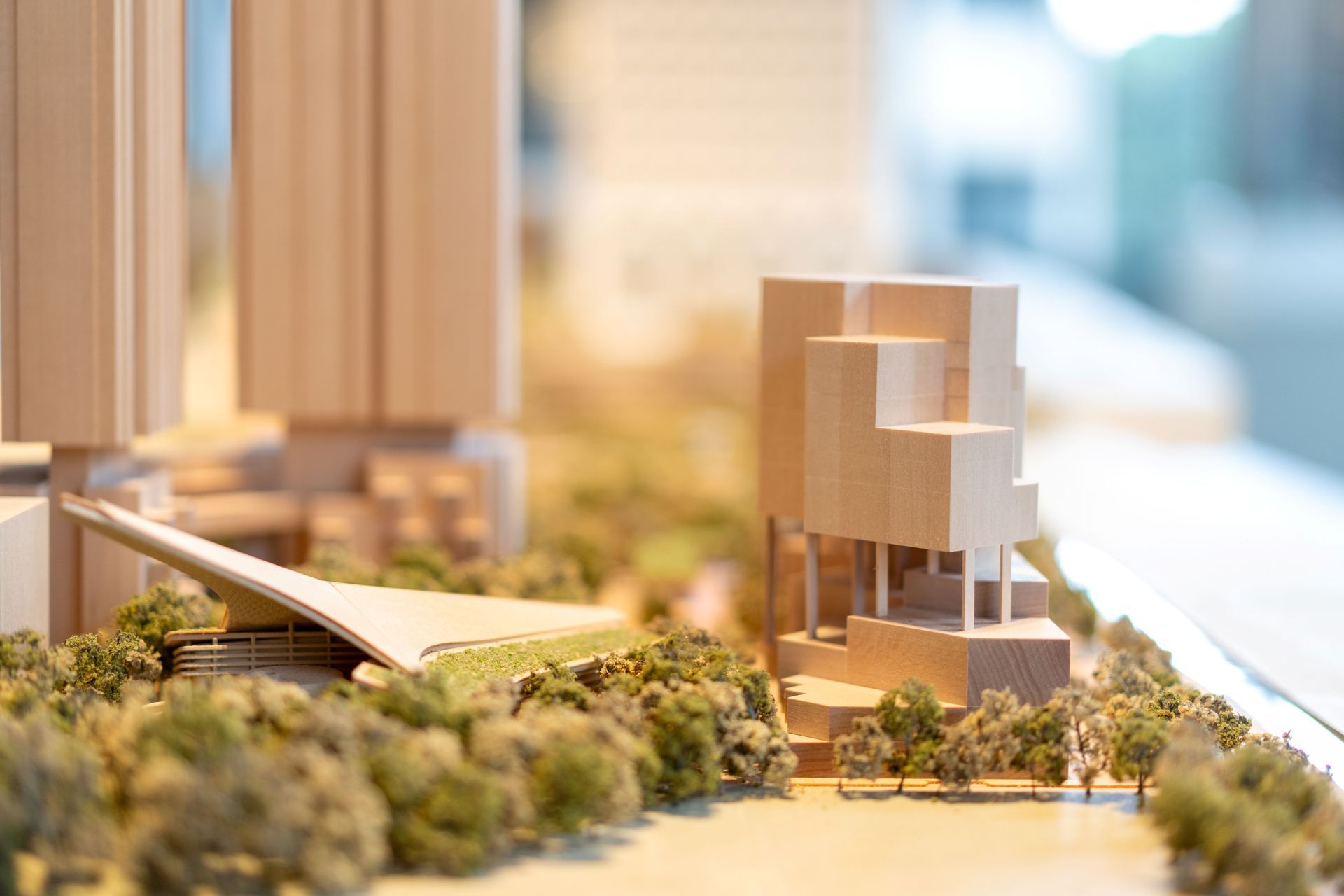 Architectural model: buildings with varying heights and shapes, surrounded by miniature trees.