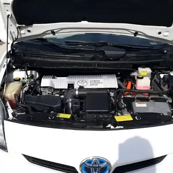 White Toyota Prius engine bay, hood open, showing hybrid system components.
