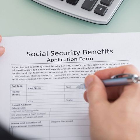 Close-Up of Person Hand Filling Social Security Benefits Form — Moulton, AL — David L Martin Attorney at Law