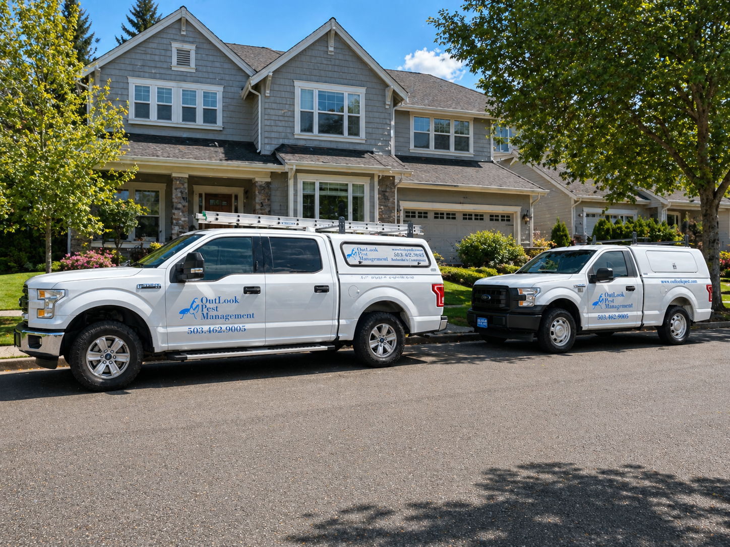 Two OutLook Pest Management service trucks parked in front of a clean upscale residential property in Hillsboro, Oregon, showcasing professional pest control vehicles in a well-maintained neighborhood setting with manicured landscaping and suburban homes.