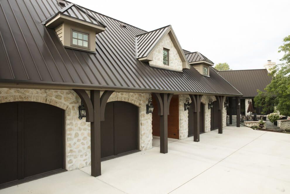 A large house with a lot of garages and a brown roof.