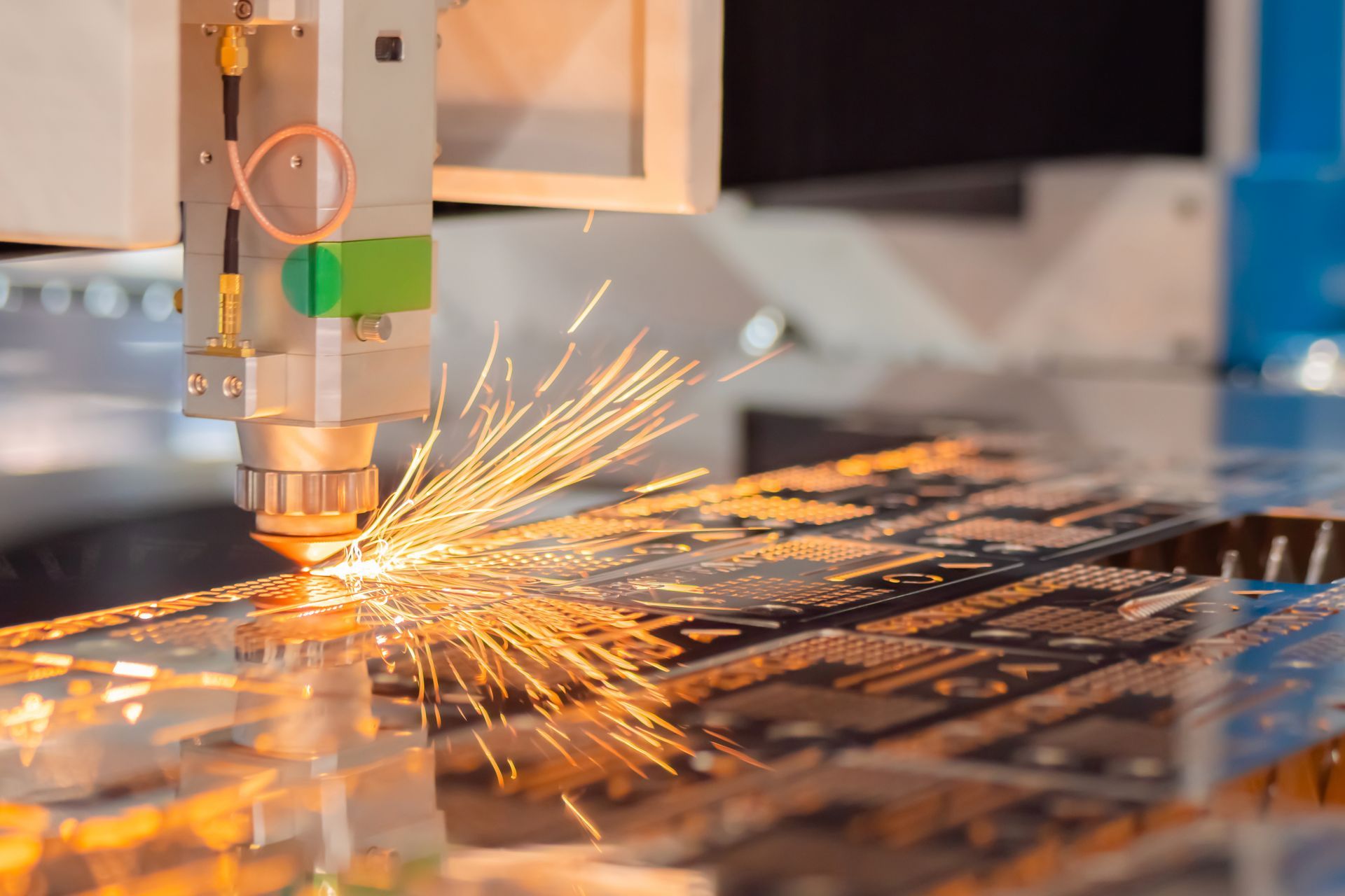 Une machine coupe un morceau de métal et des étincelles en sortent.