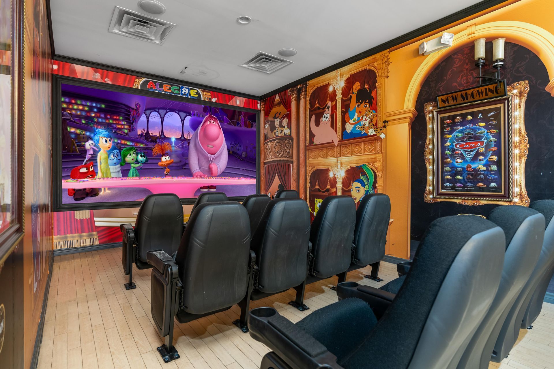 A movie theater with a large screen and black seats