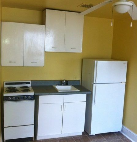 A kitchen with a stove a refrigerator and a sink