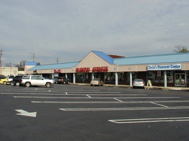A parking lot with cars parked in front of a store called market circus