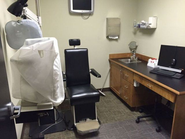A doctor 's office with a chair and a computer