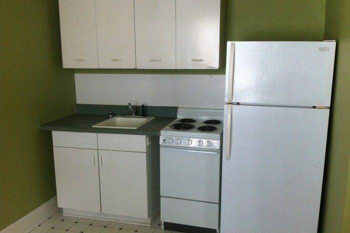 A small kitchen with a refrigerator stove and sink