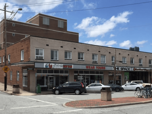 Cars are parked in front of a building that says wear yours