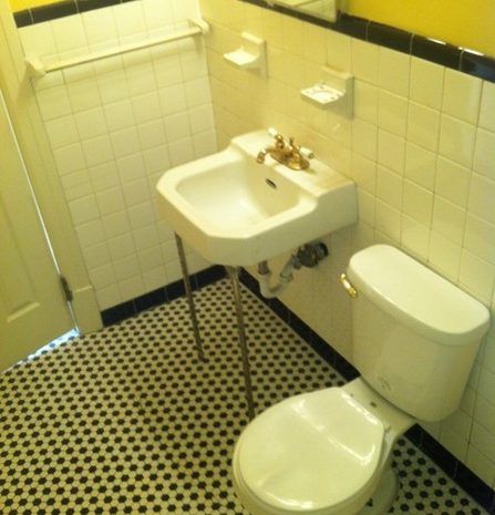 A bathroom with a toilet a sink and a mirror