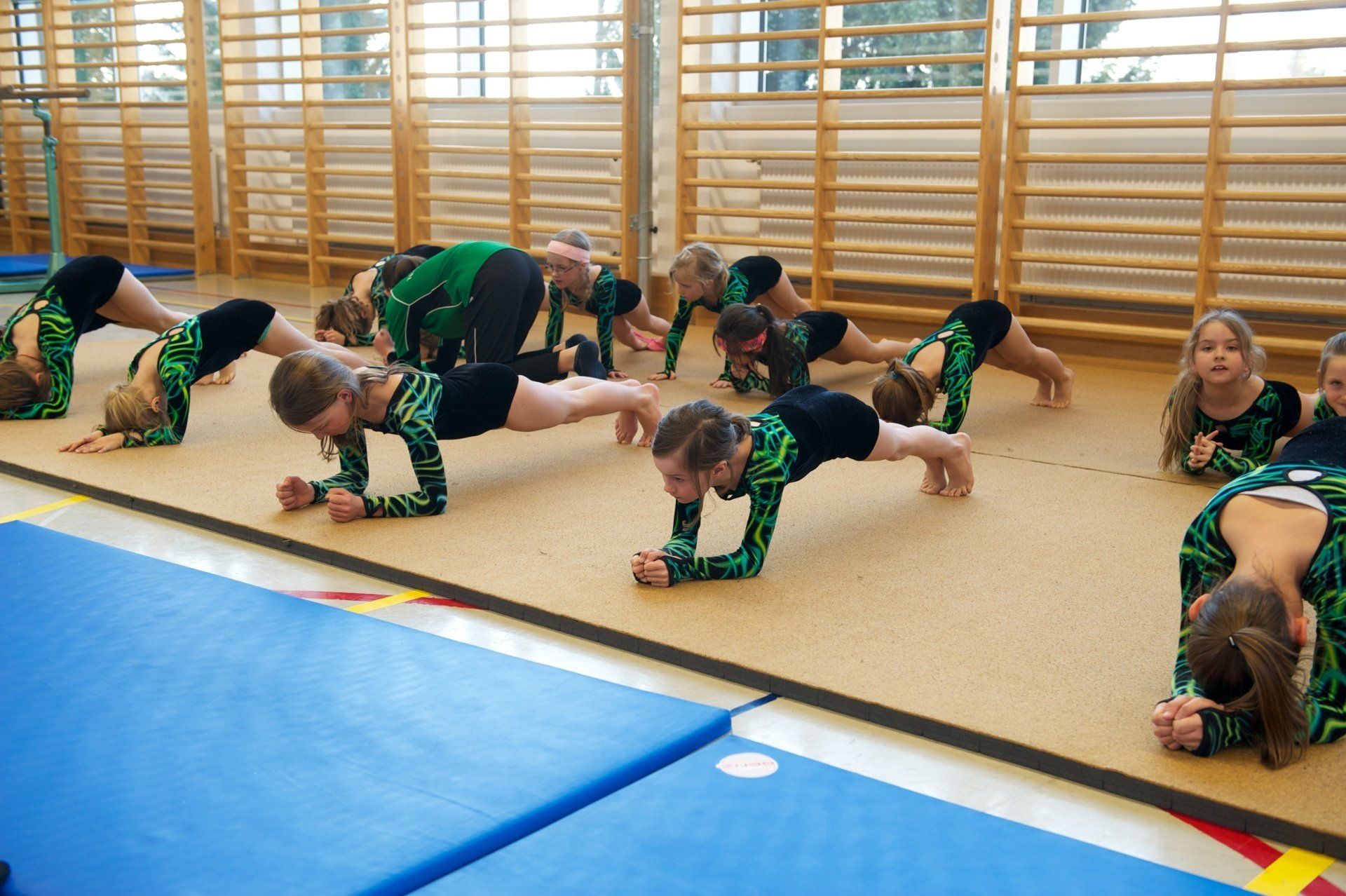 Eine Gruppe junger Mädchen macht Liegestütze in einem Fitnessstudio