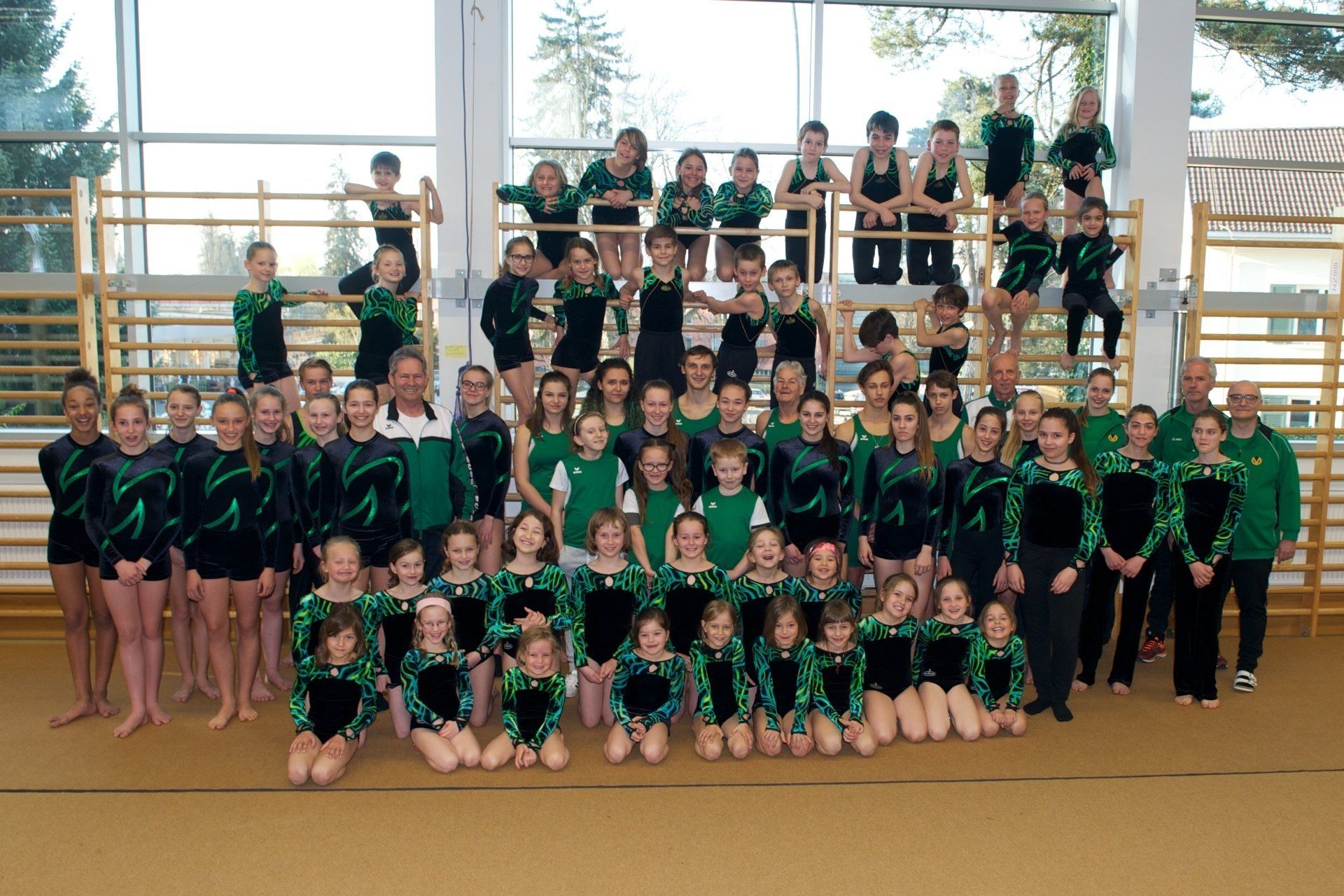 Eine große Gruppe von Menschen posiert für ein Foto in einem Fitnessstudio