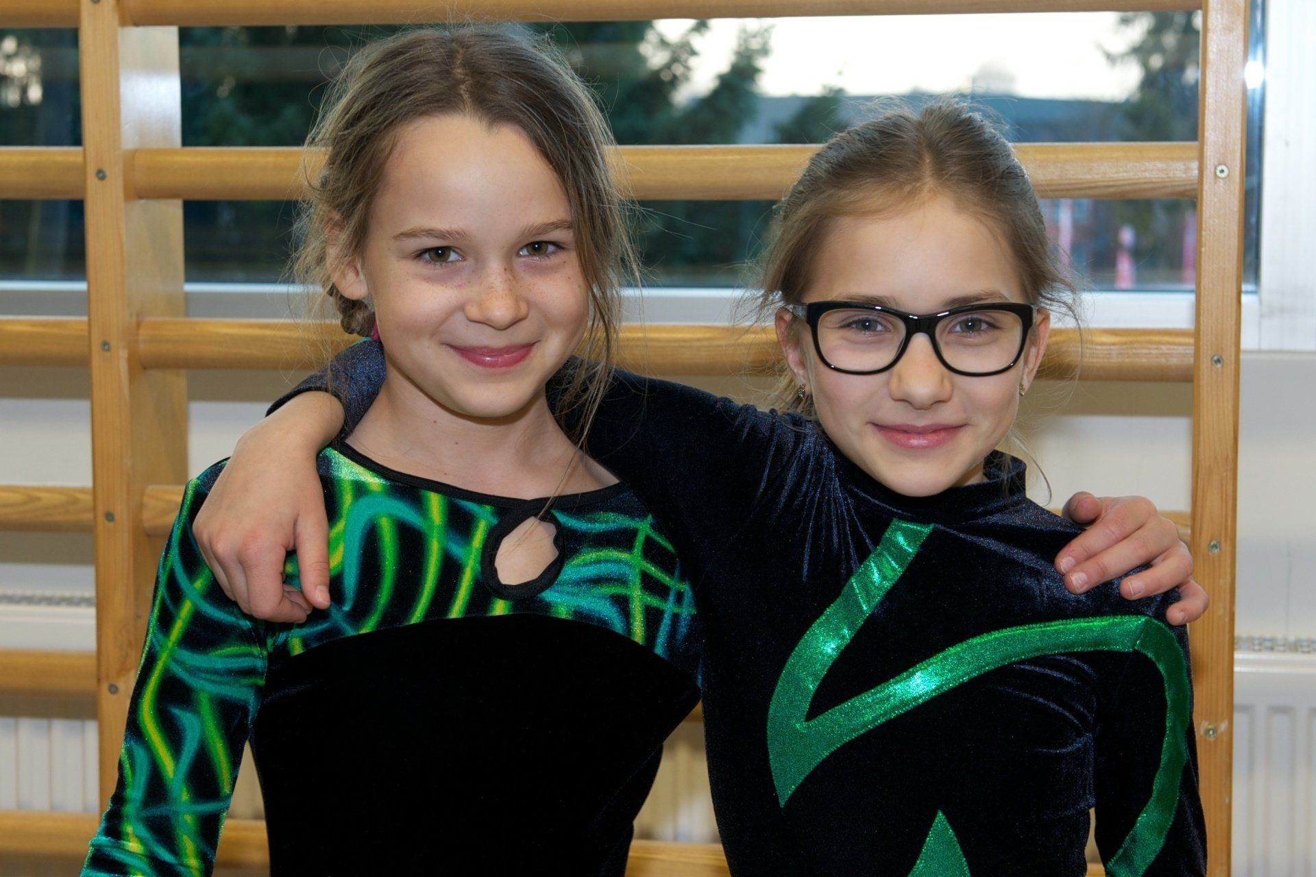Zwei junge Mädchen posieren für ein Foto und eines trägt eine Brille