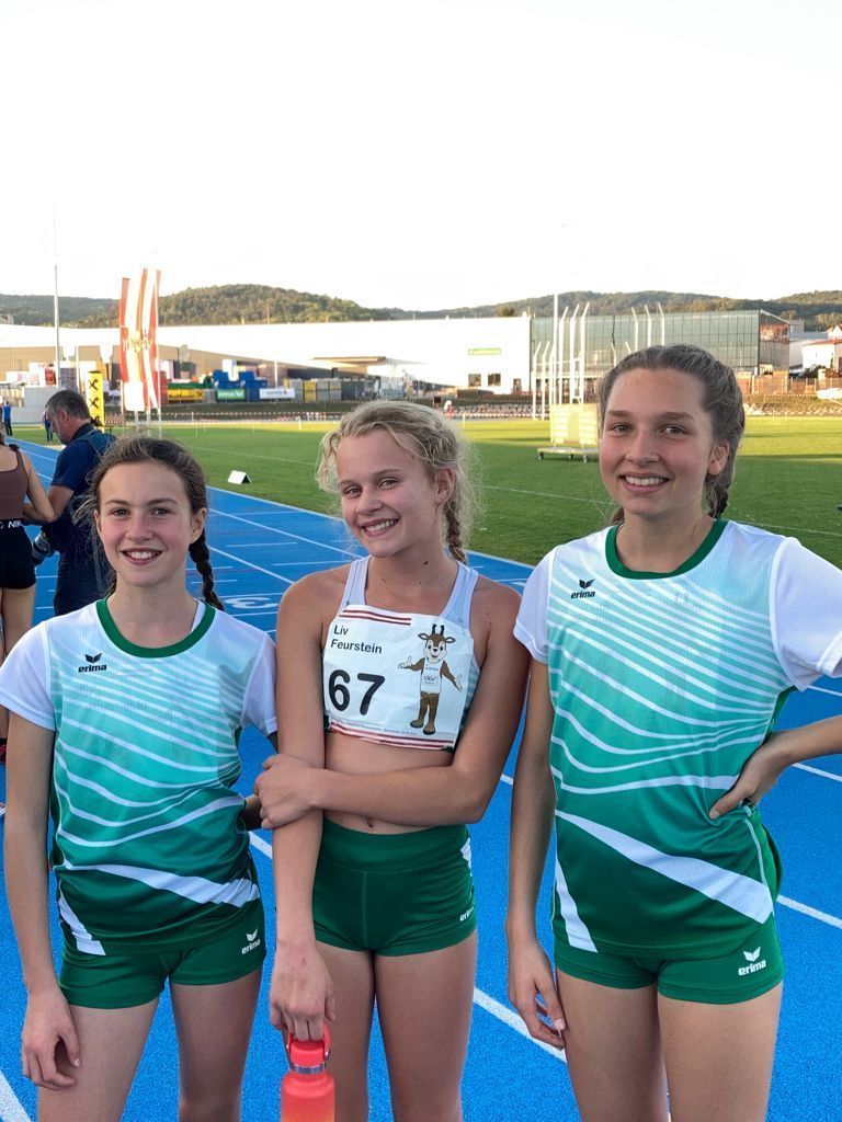 Drei junge Mädchen posieren auf einem Gleis für ein Foto.