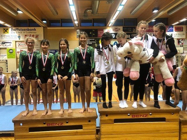 Eine Gruppe junger Mädchen steht auf einem Podium und hält Stofftiere