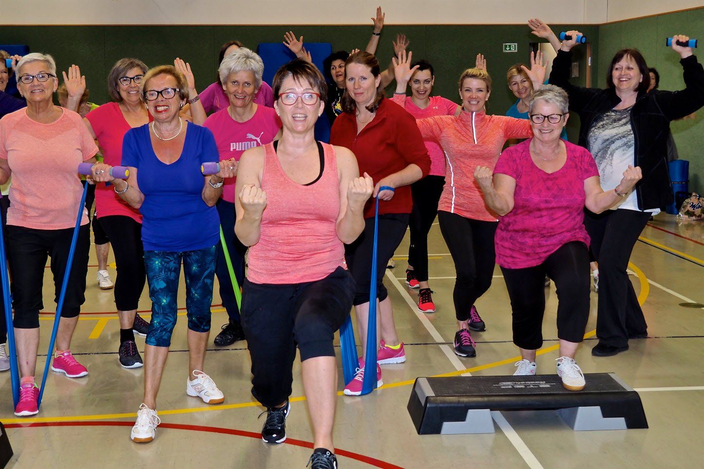 Eine Gruppe von Frauen macht in einem Fitnessstudio Übungen.
