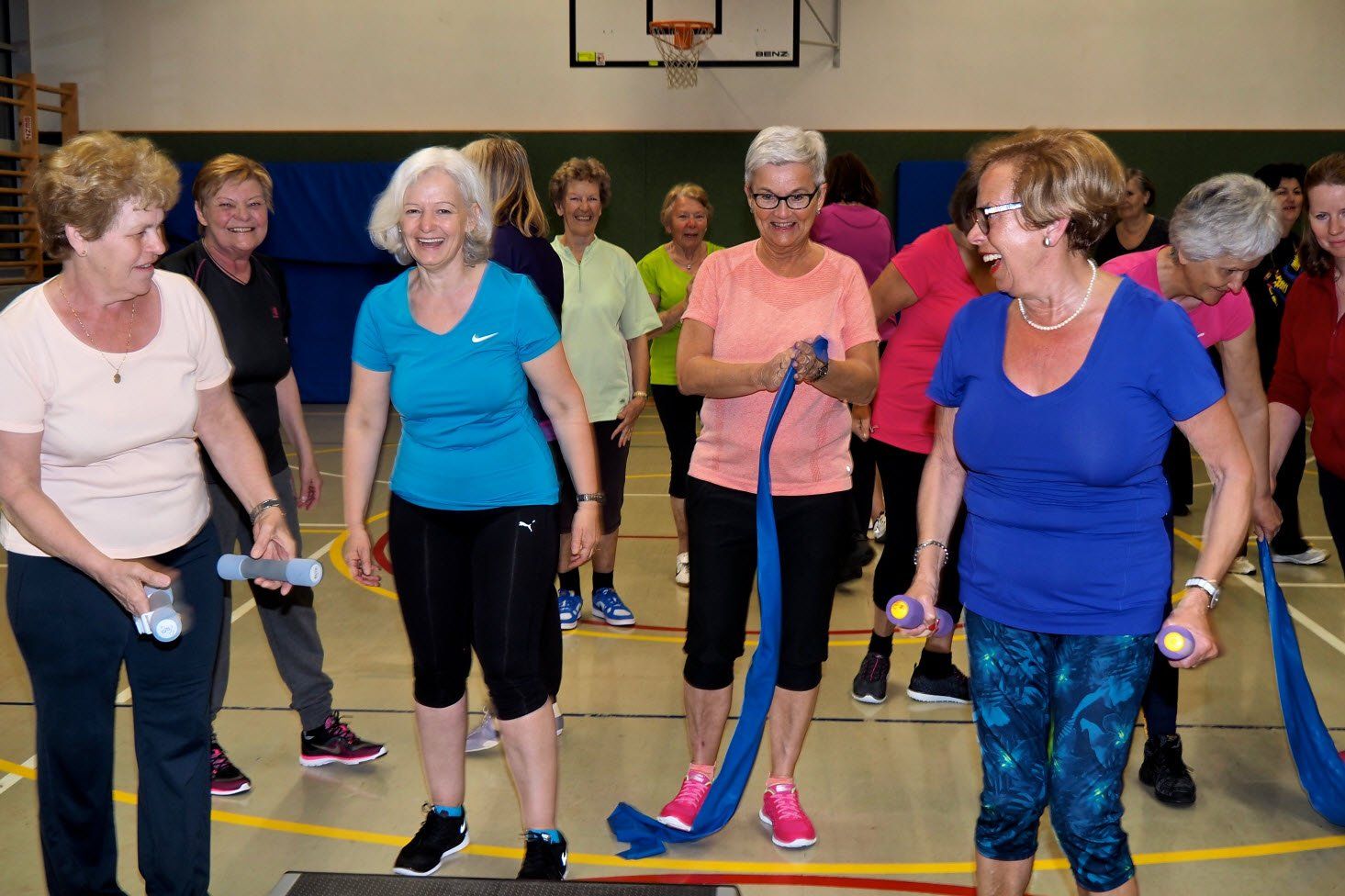 Eine Gruppe älterer Frauen macht Übungen in einem Fitnessstudio.