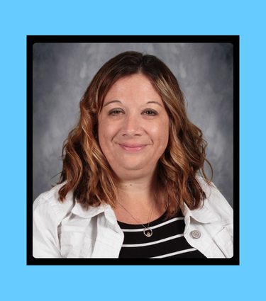 Woman with light brown hair smiles, wearing a black and white striped shirt and a white jacket.