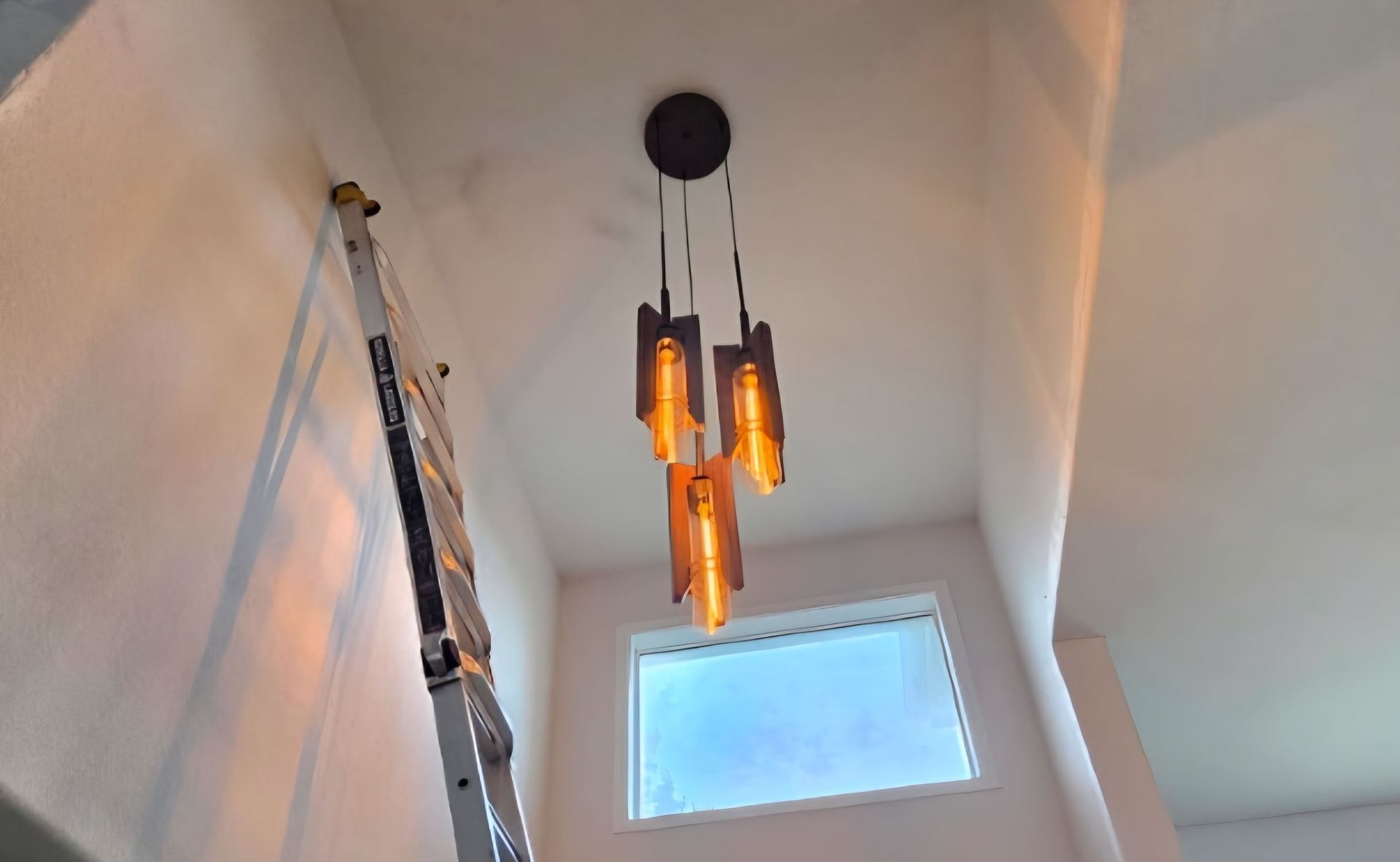 Ceiling fan with light fixture centered over a mirror, mounted on a white ceiling and walls.