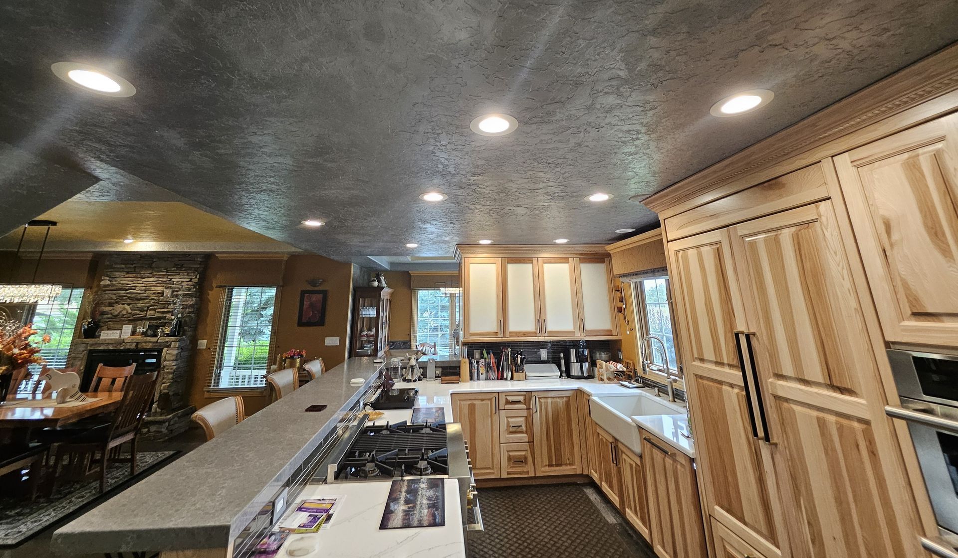 Kitchen with light wood cabinets, gray countertops, and stainless steel appliances.