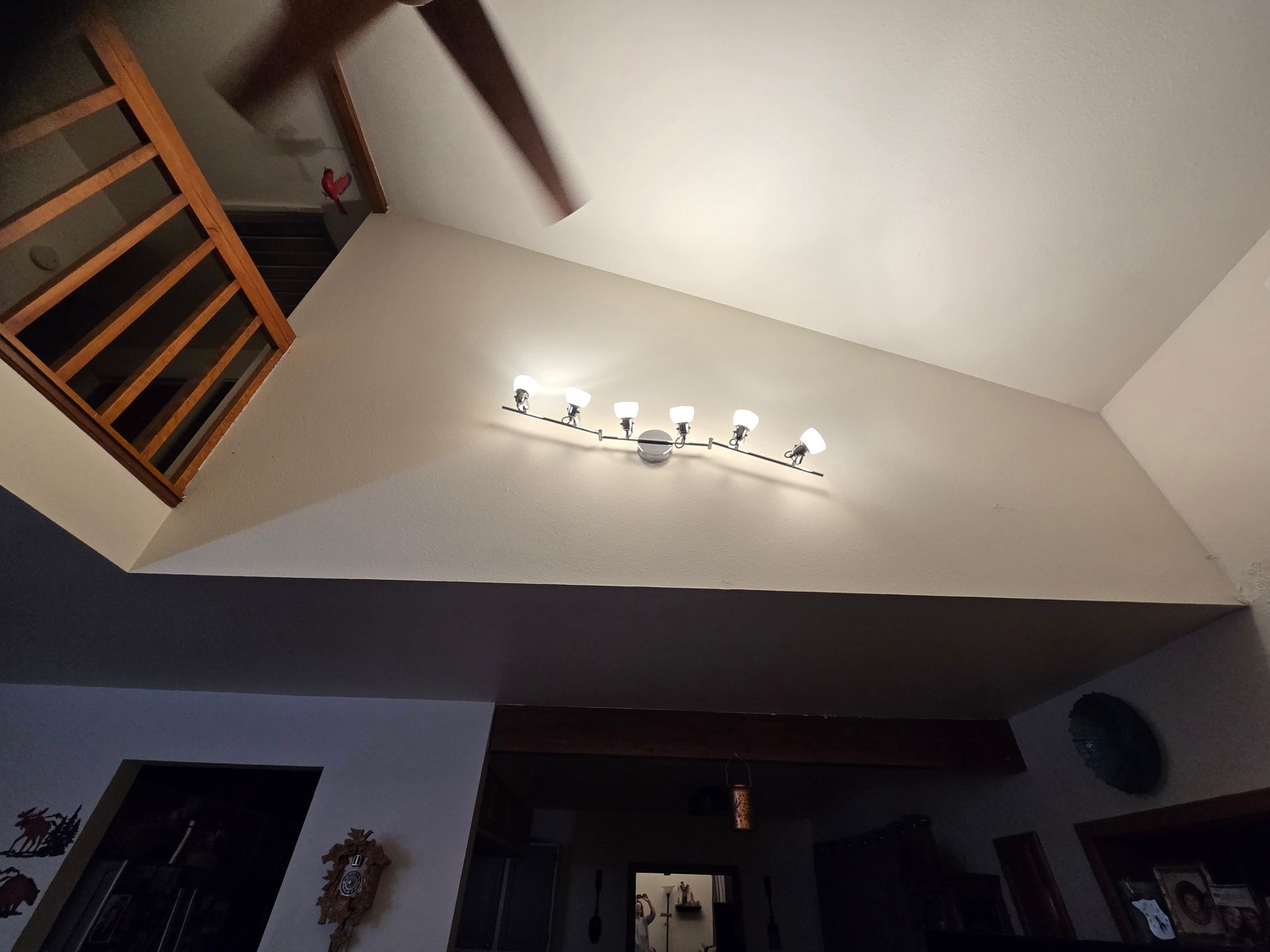 High-angle view of a room with a sloped ceiling, light fixture, and a partial view of a staircase.