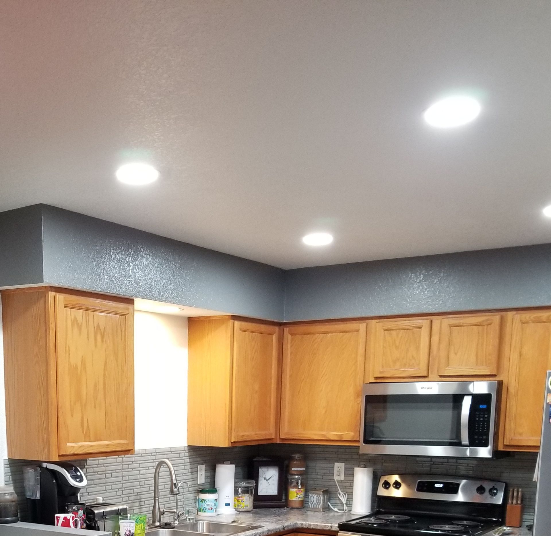 Kitchen with wooden cabinets, stainless steel appliances, and recessed lighting.