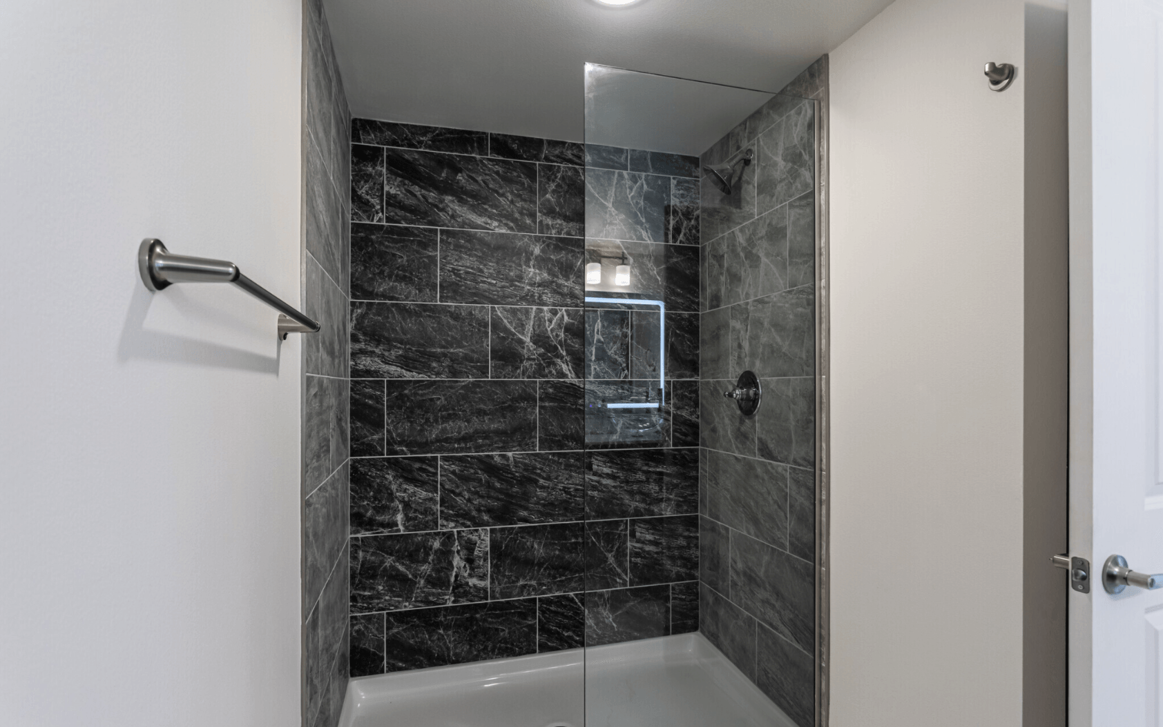 Interior of large bathroom with tile and glass door