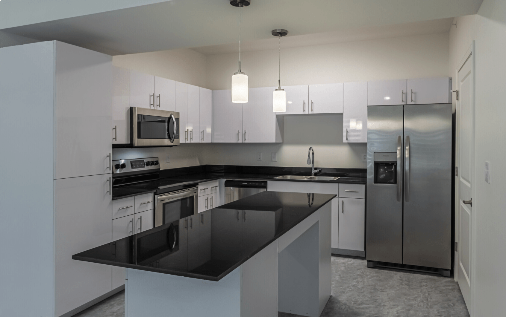 Interior of kitchen with white cabinetry and stainless steel appliances