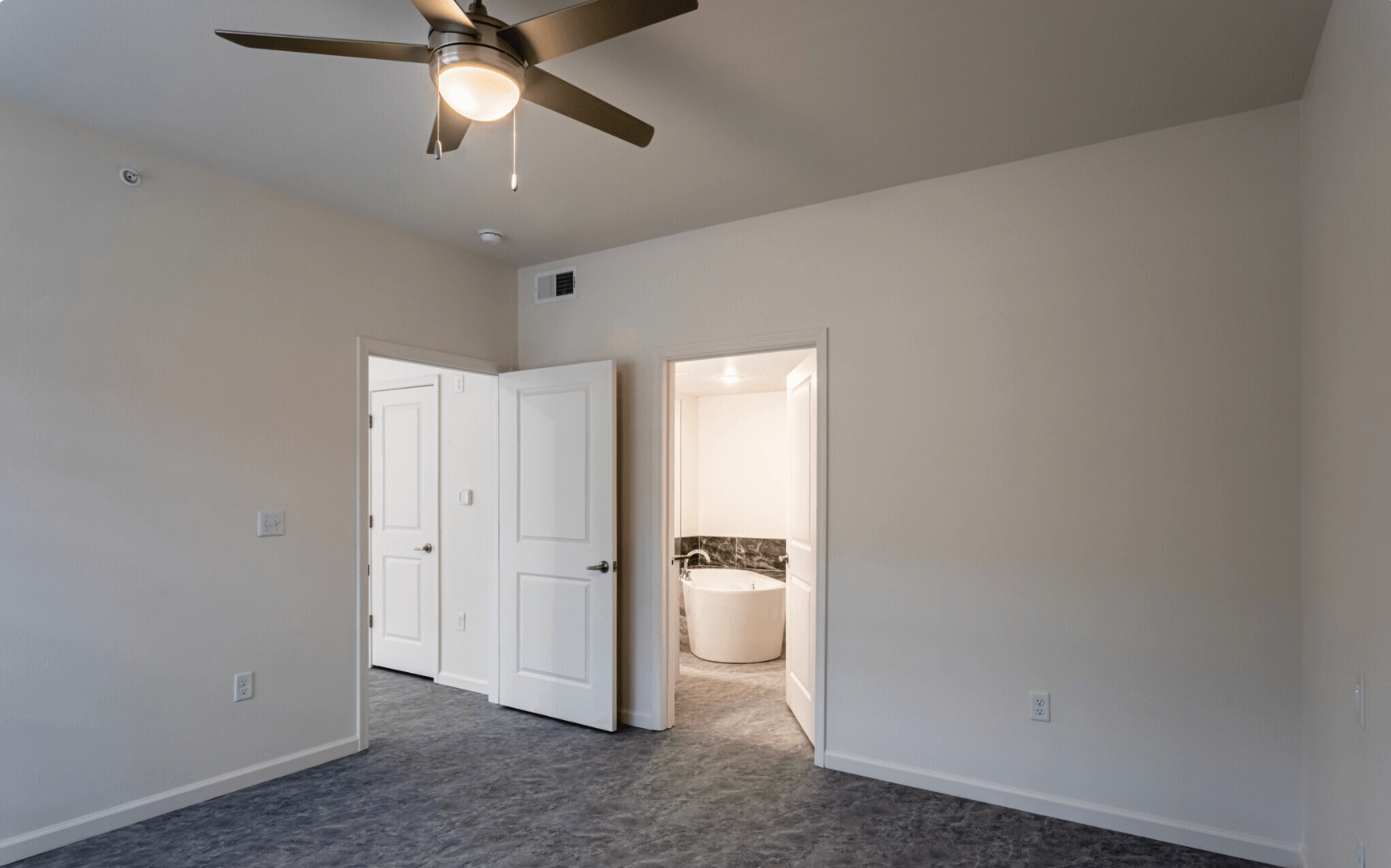 Interior of bedroom with view into living room and bathroom
