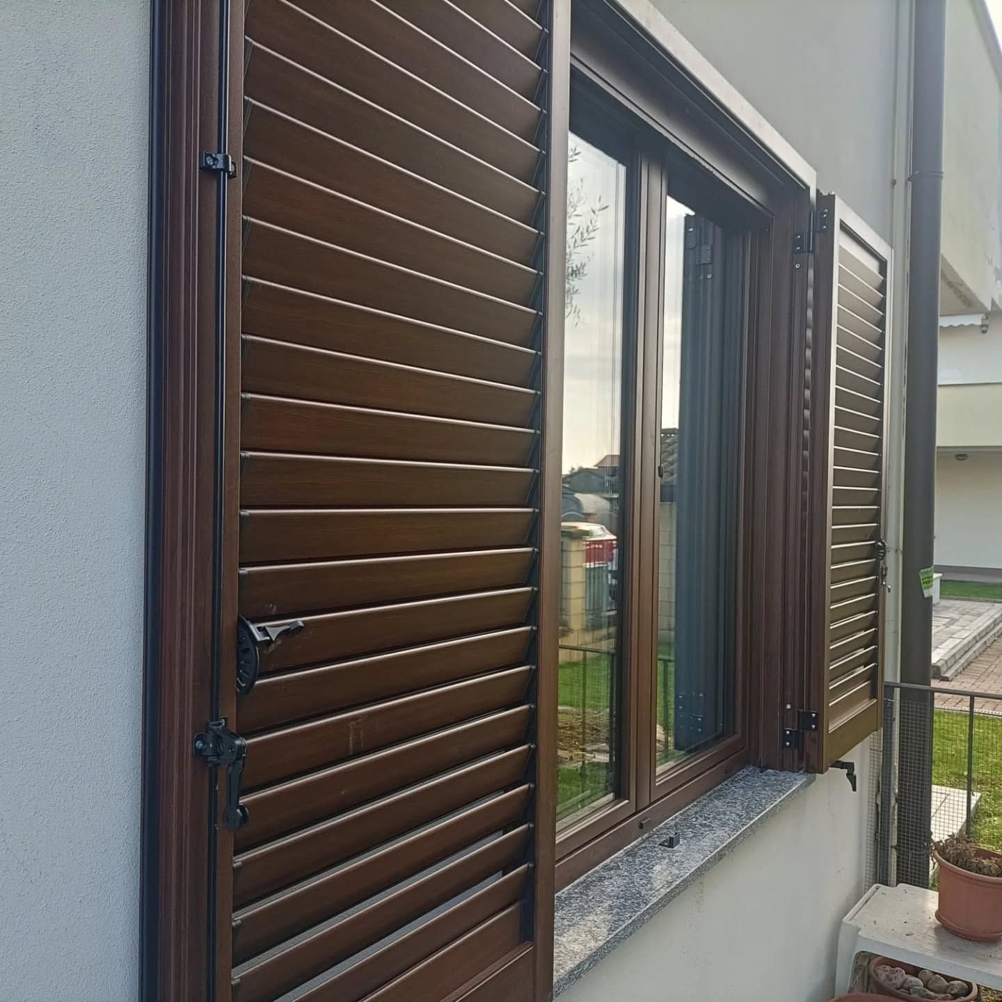 Esterno di un edificio moderno con porta del garage chiusa e finestre riflettenti.