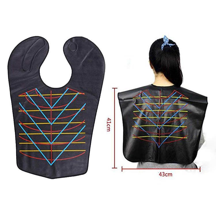 Capa negra de peluquería para teñir el cabello mostrada extendida y puesta sobre una persona